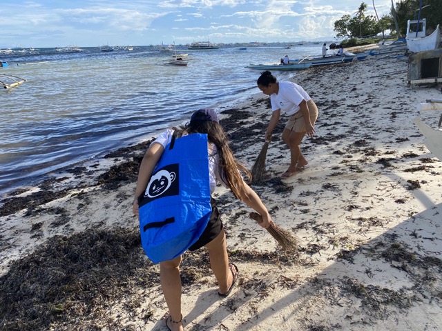 Guests collect trash on the beach in Panglao