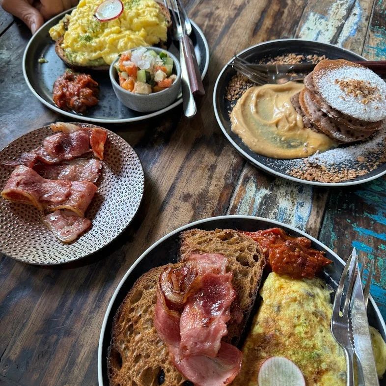 variety of brunch dishes, pancakes, bacons, bread, omelette